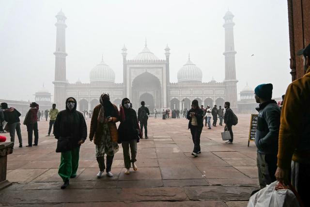 People visit the Jama Masjid (mosque) amid dense fog on a cold winter morning in the walled city area of New Delhi on January 15, 2025. (Photo by Arun SANKAR / AFP)