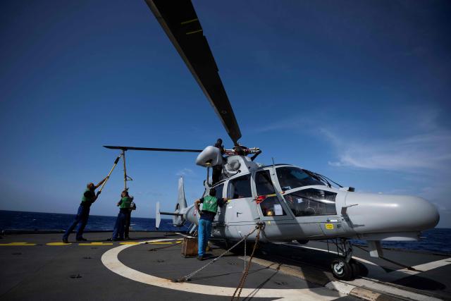 Aero team mechanics prepare the Eurocopter AS565 Panther military helicopter for a medical evacuation mission aboard the French surveillance frigate FS Ventose das it sails on a mission off French Caribbean island of Martinique, on November 14, 2024. The French surveillance frigate FS Ventose is deployed at sea on a Narcops mission to intercept narco-traffickers' vessels potentially transporting narcotics, as part of the fight against drug trafficking in the French West Indies. (Photo by JULIEN DE ROSA / AFP)