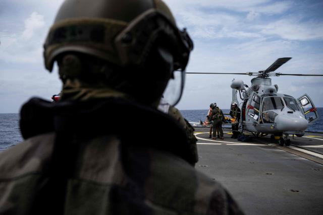 French navy personnel carry a patient on a stretcher brought aboard the French surveillance frigate FS Ventose during a medical evacuation mission by Eurocopter AS565 Panther military helicopter aboard the ship sailing on a mission off the French Caribbean island of Martinique, on November 14, 2024. The French surveillance frigate FS Ventose is deployed at sea on a Narcops mission to intercept narco-traffickers' vessels potentially transporting narcotics, as part of the fight against drug trafficking in the French West Indies. (Photo by JULIEN DE ROSA / AFP)