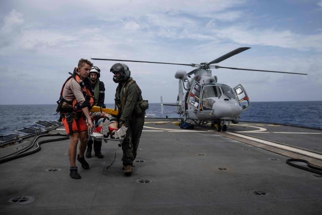 French navy personnel carry a patient on a stretcher brought aboard the French surveillance frigate FS Ventose during a medical evacuation mission by Eurocopter AS565 Panther military helicopter aboard the ship sailing on a mission off the French Caribbean island of Martinique, on November 14, 2024. The French surveillance frigate FS Ventose is deployed at sea on a Narcops mission to intercept narco-traffickers' vessels potentially transporting narcotics, as part of the fight against drug trafficking in the French West Indies. (Photo by JULIEN DE ROSA / AFP)