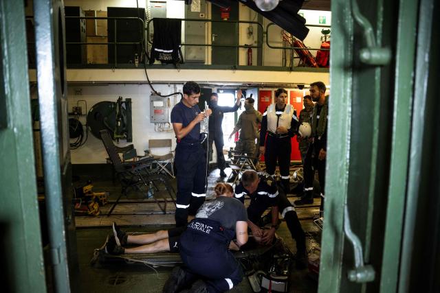 Members of the French Navy's medical team treat a patient brought aboard the French surveillance frigate FS Ventose during a medical evacuation mission by Eurocopter AS565 Panther military helicopter on the ship as it sails on a mission off the French Caribbean island of Martinique, on November 14, 2024. The French surveillance frigate FS Ventose is deployed at sea on a Narcops mission to intercept narco-traffickers' vessels potentially transporting narcotics, as part of the fight against drug trafficking in the French West Indies. (Photo by JULIEN DE ROSA / AFP)