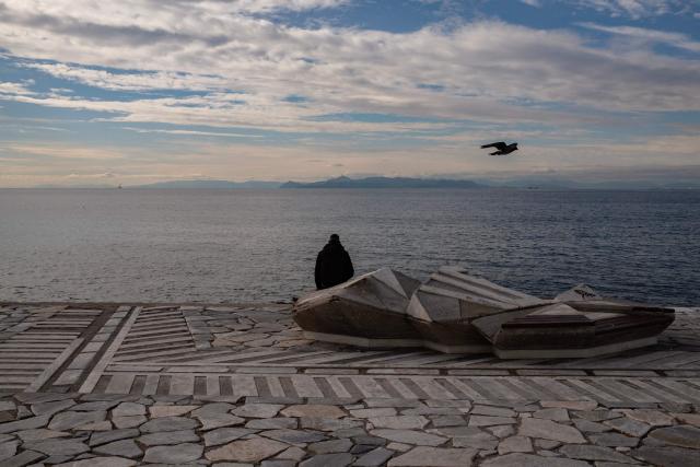 A man sits on a concrete seat at Alimos beach near Athens on January 15, 2025. (Photo by Angelos TZORTZINIS / AFP)