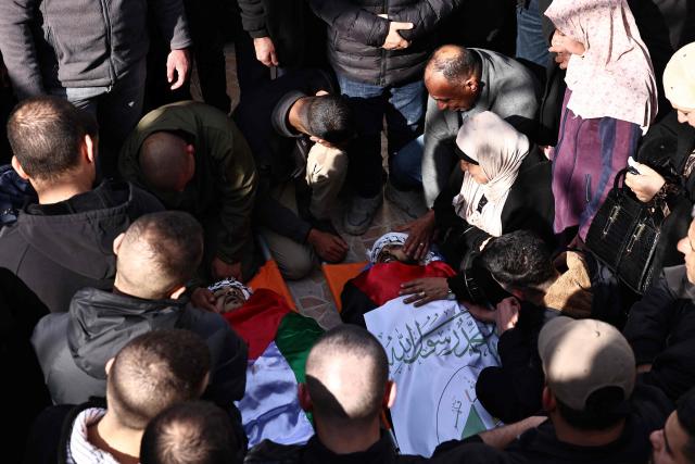 Relatives mourn over the bodies of three Palestinian brothers, Amir, Baha and Moamen Abul-Haija, who were killed during an Israeli air strike the previous day on Jenin's reugee camp in the occupied West Bank, on January 15, 2025. The Palestinian health ministry said on January 14 that an Israeli air strike on the Jenin refugee camp killed six people, including a teenager, with the Israeli military confirming it carried out an attack in the area. (Photo by Zain JAAFAR / AFP)