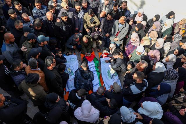 Relatives and friends mourn over the bodies of three Palestinian brothers, Amir, Baha and Moamen Abul-Haija, who were killed during an Israeli air strike the previous day on Jenin's refugee camp in the occupied West Bank, on January 15, 2025. The Palestinian health ministry said on January 14 that an Israeli air strike on the Jenin refugee camp killed six people, including a teenager, with the Israeli military confirming it carried out an attack in the area. (Photo by Zain JAAFAR / AFP)