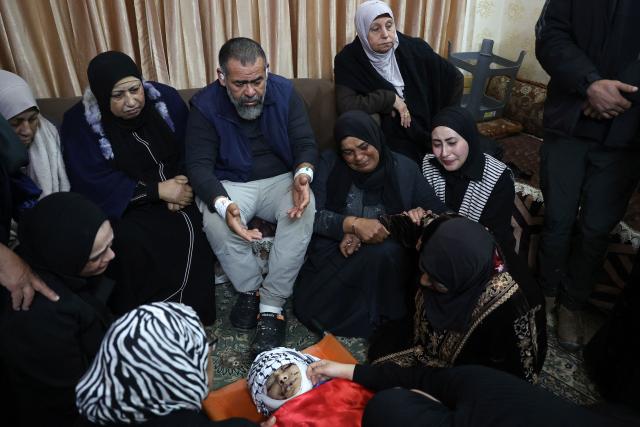 EDITORS NOTE: Graphic content / Relatives mourn over the body of Palestinian Mahmoud Gharbiya, 15, who was killed along other during an Israeli air strike the previous day on Jenin's refugee camp in the occupied West Bank, during a funeral procession, on January 15, 2025. The Palestinian health ministry said on January 14 that an Israeli air strike on the Jenin refugee camp killed six people, including a teenager, with the Israeli military confirming it carried out an attack in the area. (Photo by Zain JAAFAR / AFP)