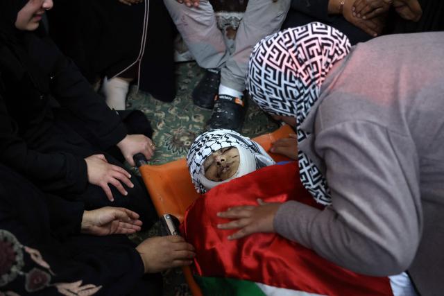 EDITORS NOTE: Graphic content / Relatives mourn over the body of Palestinian Mahmoud Gharbiya, 15, who was killed along other during an Israeli air strike the previous day on Jenin's refugee camp in the occupied West Bank, during a funeral procession, on January 15, 2025. The Palestinian health ministry said on January 14 that an Israeli air strike on the Jenin refugee camp killed six people, including a teenager, with the Israeli military confirming it carried out an attack in the area. (Photo by Zain JAAFAR / AFP)