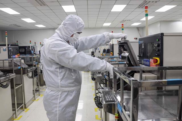 An employee produces semiconductor chips at a factory in Binzhou, in eastern China's Shandong province on January 15, 2025. (Photo by AFP) / China OUT