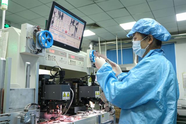 An employee produces semiconductor chips at a factory in Binzhou, in eastern China's Shandong province on January 15, 2025. (Photo by AFP) / China OUT