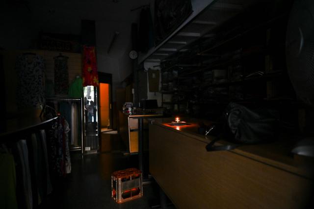 A candle is pictured inside a store during a blackout in Buenos Aires on January 16, 2025. The National Weather Service issued an alert for "extreme temperatures" in central and northern Argentina, affecting 17 of the country's 23 provinces, including Buenos Aires, where due to the heat and high demand for electricity, nearly 40,000 homes suffered blackouts. (Photo by LUIS ROBAYO / AFP)