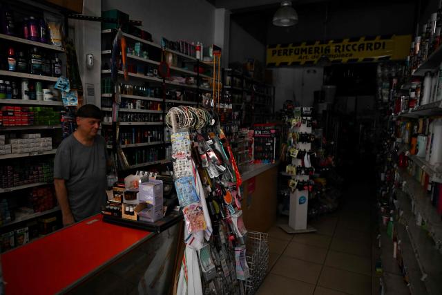 A man waits for customers at a store during a blackout in Buenos Aires on January 16, 2025. The National Weather Service issued an alert for "extreme temperatures" in central and northern Argentina, affecting 17 of the country's 23 provinces, including Buenos Aires, where due to the heat and high demand for electricity, nearly 40,000 homes suffered blackouts. (Photo by LUIS ROBAYO / AFP)