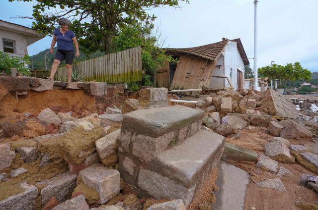 A woman inspect the damage caused by heavy rains at Sambaqui neighborhood in Florianopolis, Santa Catarina state, Brazil on January 17, 2025. (Photo by Ricardo Wolffenbuttel / AFP)