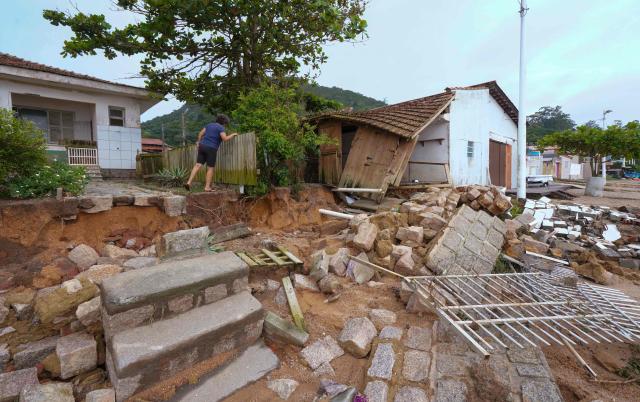 A woman inspect the damage caused by heavy rains at Sambaqui neighborhood in Florianopolis, Santa Catarina state, Brazil on January 17, 2025. (Photo by Ricardo Wolffenbuttel / AFP)