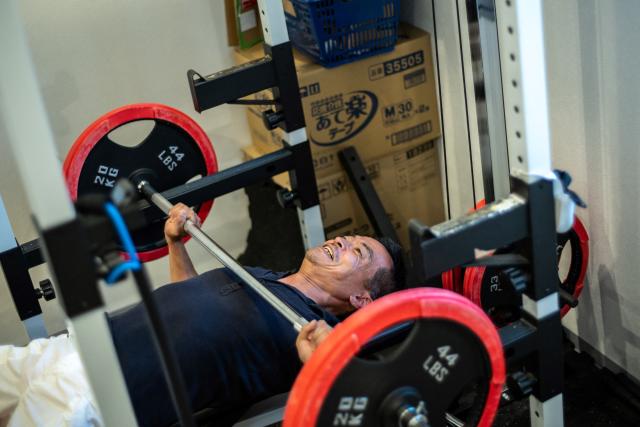 This picture taken on October 21, 2024 shows Ueko (nickname) a parolee recovering from drug addiction, doing weight lifting workout at a drug rehab centre in Sakai city of Osaka Prefecture. Around 47,000 citizen volunteers known as "hogoshi" far outnumber the 1,000 salaried probation officers working in Japan. (Photo by Philip FONG / AFP) / TO GO WITH: Japan-social-crime-prison-volunteer, FEATURE by Tomohiro OSAKI