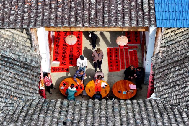 This photo taken on January 26, 2025 shows villagers writing spring couplets, a kind of Lunar New Year decorations, ahead of the up coming Lunar New Year of the Snake in Liuzhou, southwest China's Guangxi province. (Photo by AFP) / China OUT