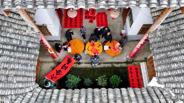 This photo taken on January 26, 2025 shows villagers writing spring couplets, a kind of Lunar New Year decorations, ahead of the up coming Lunar New Year of the Snake in Liuzhou, southwest China's Guangxi province. (Photo by AFP) / China OUT