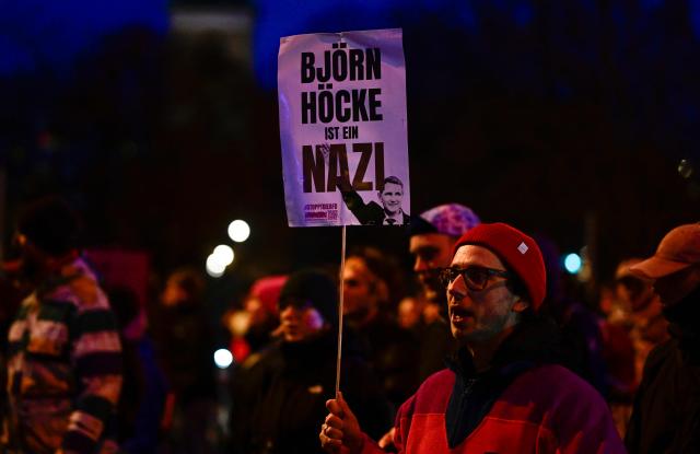 A sign reading "Bjoern Hoecke is a Nazi" referring to AfD parliamentary group leader  at the regional parliament in Thuringia Bjoern Hoecke, is held up near Berlin's landmark TV tower during a protest named "Eat the rich” on January 27, 2025 in Berlin, against right-wing extremism and an economic summit of German newspaper Welt held at the Axel Springer publishing house. (Photo by John MACDOUGALL / AFP)