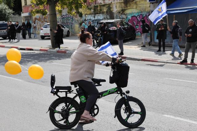 Israelis wave the national flag outside the entrance to the National Center of Forensic Medicine in Tel Aviv on February 20, 2025, ahead of the arrival of the bodies of the four Israeli hostages to undergo an identification process. Hamas handed over the bodies of four hostages on February 20, including those of the Bibas family, who have become symbols of the hostage crisis that has gripped Israel since the Gaza war broke out. The transfer of the bodies is the first such handover of remains by Hamas since its October 7, 2023 attack on Israel triggered the war. (Photo by Jack GUEZ / AFP)