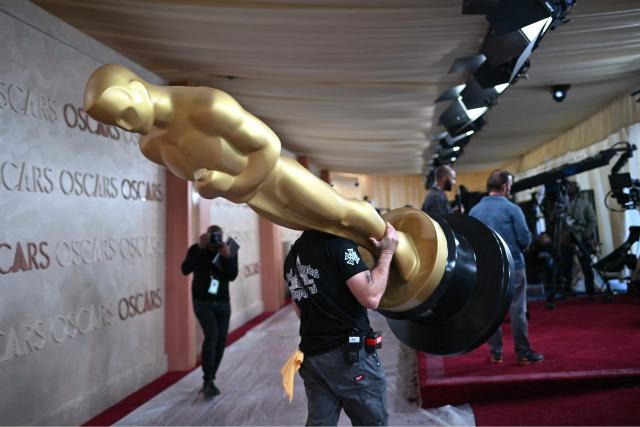 An Oscar statue is carried as preparations are made on the red carpet for the 97th Annual Academy Awards outside the Dolby Theatre in Hollywood, California, on February 28, 2025. (Photo by ANGELA WEISS / AFP)