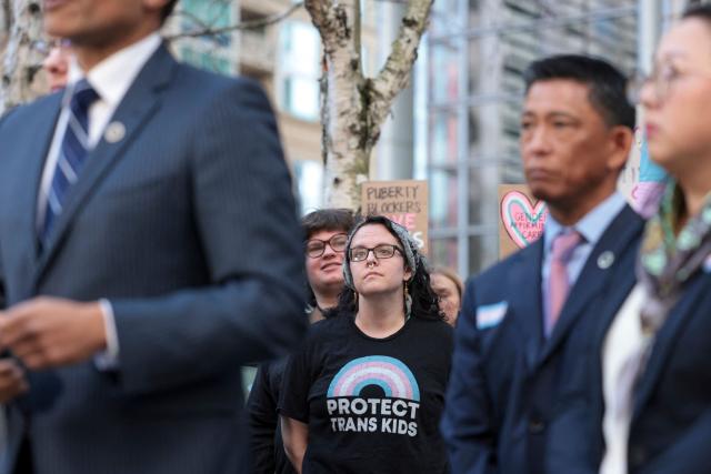 Taren, a mother of a trans child and one of the plaintiffs who did not want to use her last name, listens as Washington State Attorney General Nick Brown speaks to the media and supporters outside the US District Court for the Western District of Washington in Seattle, Washington, February 28, 2025. Brown spoke to the press after US District Judge Lauren King announced they are deliberating on whether to extend a pause on US President Donald Trump’s executive order attacking gender-affirming care for youth. (Photo by Jason Redmond / AFP)