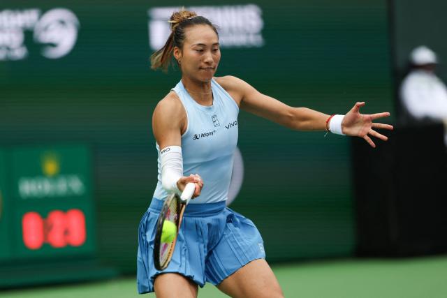 China’s Qinwen Zheng returns the ball to Poland’s Iga Swiatek during a quarterfinal women’s singles match of the BNP Paribas Open at the Indian Wells Tennis Garden in Indian Wells, California on March 13, 2025. (Photo by Patrick T. Fallon / AFP)