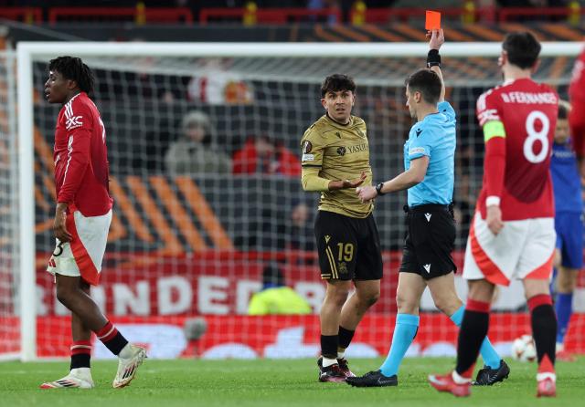 French referee Benoît Bastien shows a red card to Real Sociedad's Venezuelan defender #19 Jon Aramburu for his foul on Manchester United's Danish defender #13 Patrick Dorgu (L) during the UEFA Europa League Last 16 Second Leg football match between Manchester United and Real Sociedad at Old Trafford stadium in Manchester, north west England, on March 13, 2025. (Photo by Darren Staples / AFP)