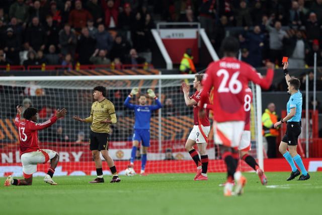 French referee Benoît Bastien shows a red card to Real Sociedad's Venezuelan defender #19 Jon Aramburu for his foul on Manchester United's Danish defender #13 Patrick Dorgu (L) during the UEFA Europa League Last 16 Second Leg football match between Manchester United and Real Sociedad at Old Trafford stadium in Manchester, north west England, on March 13, 2025. (Photo by Darren Staples / AFP)