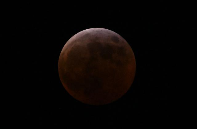 The full moon, also known as the "blood moon," is seen in Mexico City on March 13, 2025, during the lunar eclipse. (Photo by Yuri CORTEZ / AFP)