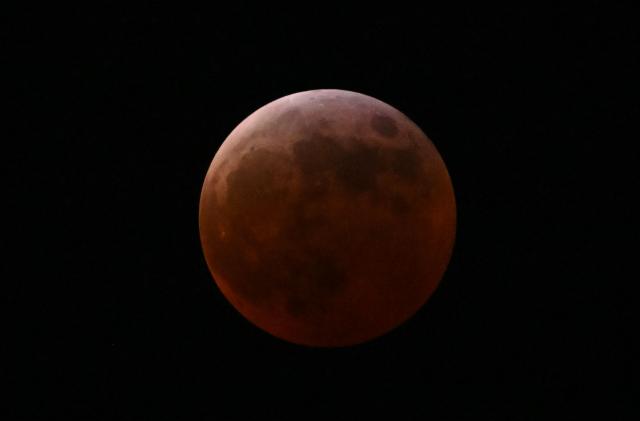 The full moon, also known as the "blood moon," is seen in Mexico City on March 13, 2025, during the lunar eclipse. (Photo by Yuri CORTEZ / AFP)