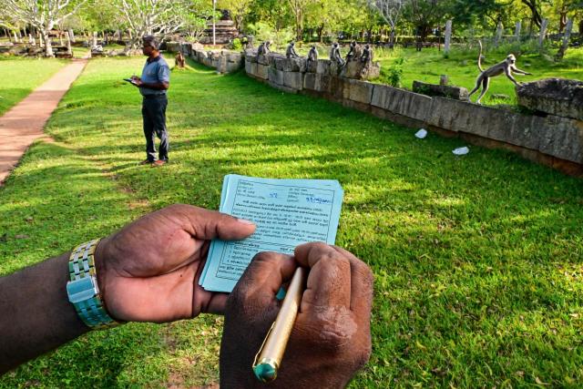 Divisional secretariat at the Mihintale village mark tally sheets after counting monkeys as they conduct a census in Anuradhapura on March 15, 2025. Sri Lanka carried out a nationwide census on March 15, of nuisance wildlife, including monkeys and peacocks, in a bid to prepare countermeasures to protect crops, officials said. (Photo by Ishara S. KODIKARA / AFP)