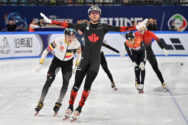 Canada’s William Dandjinou (C) celebrates after winning the men’s 1500 meter final at the ISU World Short Track Championships in Beijing on March 15, 2025. (Photo by ADEK BERRY / AFP)