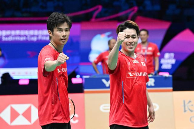 Japan's Takuro Hoki (R) and Yugo Kobayashi celebrate defeating Malaysia’s Aaron Chia and Soh Wooi Yik in their men’s doubles match at the Sudirman Cup badminton championship in Xiamen, China’s southeastern province on May 1, 2025. (Photo by ADEK BERRY / AFP)