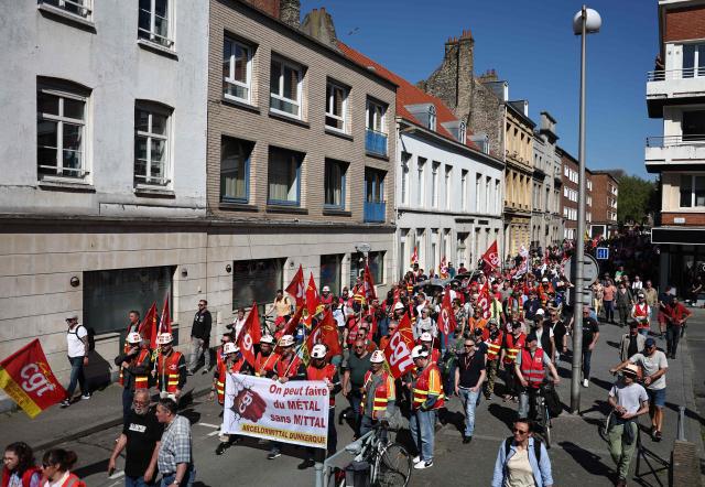 Protesters hold a banner reading "We can do steel without Mittal" during a May Day (Labour Day) rally, marking International Workers' Day, in Dunkirk, northern France, on May 1, 2025. ArcelorMittal's French trade union General Confederation of Labour (CGT) called for a major demonstration in Dunkirk on May 1, to protest against the steelmaker's plan to cut around 600 jobs in northern and eastern France. (Photo by Sameer AL-DOUMY / AFP)