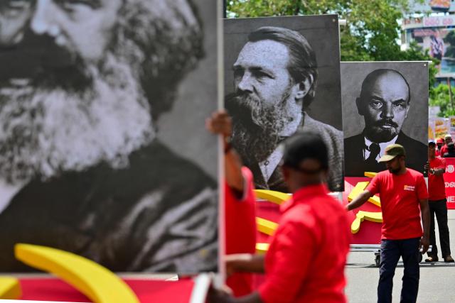 Supporters of the Frontline Socialist Party display placards with images of (L-R) Karl Marx, Friedrich Engels and Vladimir Lenin as they take part in a rally to mark International Labour Day in Colombo on May 1, 2025. (Photo by Ishara S. KODIKARA / AFP)