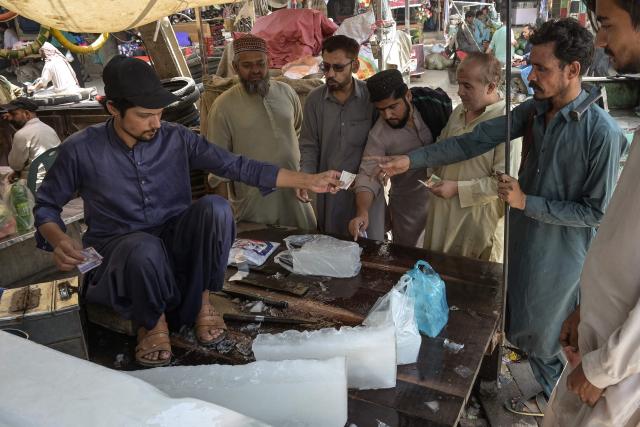 People purchase ice from a stall at a market on a hot summer day in Hyderabad, Sindh Province, on May 1, 2025. (Photo by Akram SHAHID / AFP)