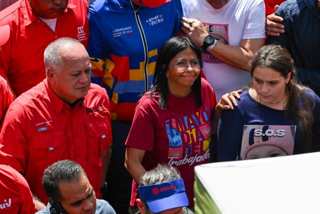 Venezuela's Interior Minister Diosdado Cabello (L) and Vice President Delcy Rodriguez (C) take part in a Labour Day march in Caracas on May 1, 2025. Venezuelan President Nicolas Maduro has increased pensions from $1.50 to $50 and welfare bonuses ahead of a controversial regional vote as the country fights chronic inflation -- but kept the $1.50 minimum monthly wage unchanged. (Photo by Juan BARRETO / AFP)