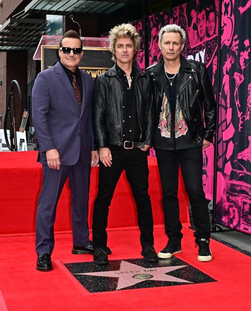 (L/R) Green Day's Tre Cool, Billie Joe Armstrong and Mike Dirnt stand on their newly unveiled star on the Hollywood Walk of Fame during a ceremony in Hollywood, California, on May 1, 2025. (Photo by Frederic J. BROWN / AFP)