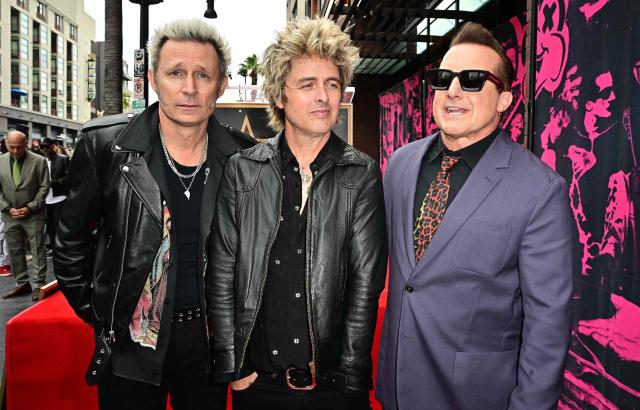 Green Day's Mike Dirnt (L), Billie Joe Armstrong (C) and Tre Cool (R) pose near their newly unveiled star on the Hollywood Walk of Fame during a ceremony in Hollywood, California, on May 1, 2025. (Photo by Frederic J. BROWN / AFP)
