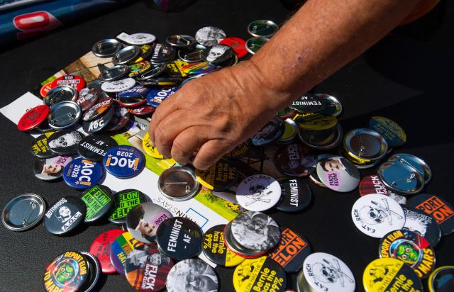 A person reaches for a pin during the “For the Workers, Not the Billionaires May Day Rally” in Philadelphia, Pennsylvania on May 1, 2025. US Senator Bernie Sanders addressed the protesters who marched and participated in an act of civil disobedience. (Photo by Matthew Hatcher / AFP)