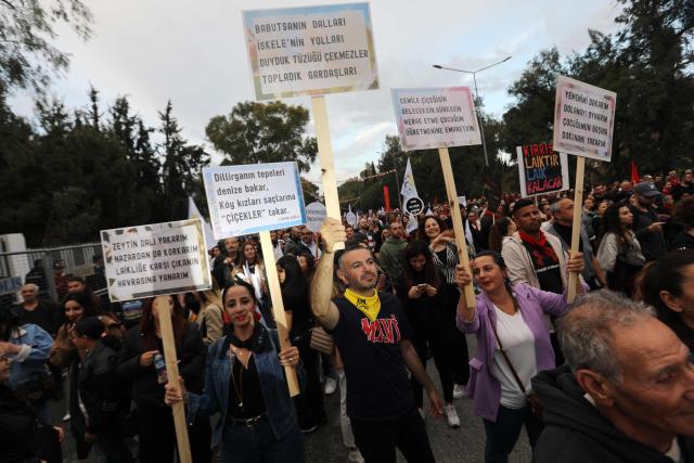 Demonstrators lift flags and placards denouncing a new regulation allowing young women to wear headscarves in secondary school during a rally in the northern part of the divided Cypriot capital Nicosia, in the self-proclaimed Turkish Republic of Northern Cyprus (TRNC) recognized only by Turkey, on February 16, 2025. The rule, introduced in March by the local authorities, received swift backlash with educators, unions and opposition leaders condemning the move as an erosion of long-held secular norms and a politicisation of the education system. (Photo by Birol BEBEK / AFP)