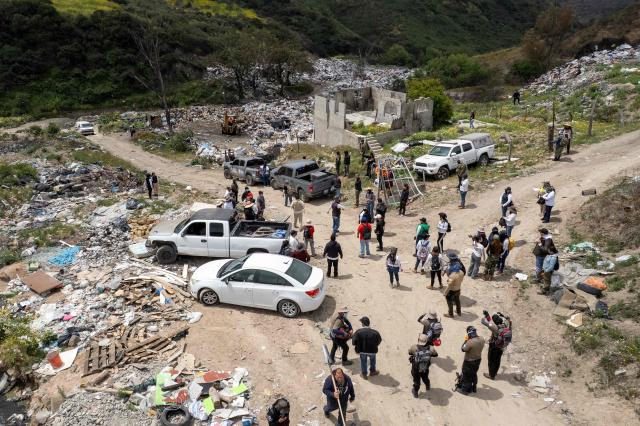 This aerial view shows members of the collective for the search of missing persons and authorities preparing to take part in a search at the Las Carretas Canyon area in Tijuana, Baja California state, Mexico on May 2, 2025. (Photo by Guillermo Arias / AFP)