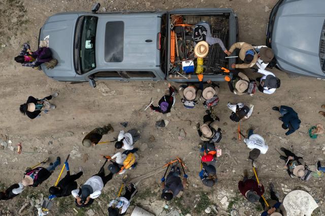 This aerial view shows members of the collective for the search of missing persons and authorities preparing to take part in a search at the Las Carretas Canyon area in Tijuana, Baja California state, Mexico on May 2, 2025. (Photo by Guillermo Arias / AFP)