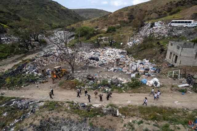 This aerial view shows members of the collective for the search of missing persons and authorities preparing to take part in a search at the Las Carretas Canyon area in Tijuana, Baja California state, Mexico on May 2, 2025. (Photo by Guillermo Arias / AFP)
