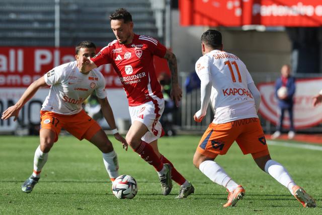 Brest's Portuguese midfielder #26 Mathias Pereira Lage (C) fights for the ball with Montpellier's French defender #17 Theo Sainte-Luce (L) and Montpellier's French midfielder #11 Teji Savanier during the French L1 football match between Stade Brestois 29 (Brest) and Montpellier Herault SC at Stade Francis-Le Ble in Brest, western France on May 4, 2025. (Photo by Fred TANNEAU / AFP)
