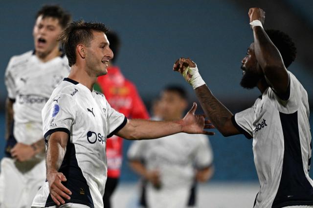 Independiente's forward #34 Matias Gimenez (L) celebrates with teammate Colombian defender #77 Alvaro Angulo after scoring his team's fourth goal during the Copa Sudamericana group stage football match between Uruguay's Boston River and Argentina's Independiente at the Centenario stadium in Montevideo on May 6, 2025. (Photo by Eitan ABRAMOVICH / AFP)