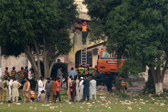 Rescuers search for victims in the debris of a damaged building of the Government Health and Educational complex after Indian strikes in Muridke, about 30 kilometres from Lahore, on May 7, 2025. India fired missiles at Pakistani territory early on May 7, killing at least eight people, according to Pakistan, which said it had begun retaliating in a major escalation between the nuclear-armed rivals. (Photo by Murtaz Ali / AFP)