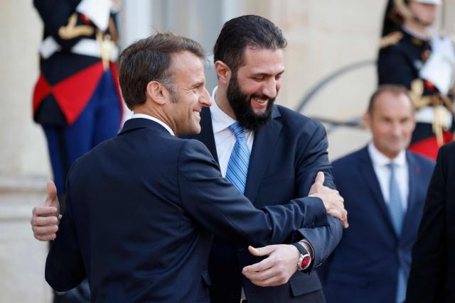 French President Emmanuel Macron (L) and Syrian President Ahmed al-Sharaa greet each other after a joint press conference following a meeting at the Elysee Palace in Paris, on May 7, 2025. Syrian interim President Ahmed al-Sharaa arrived in Paris on May 7, state media reported, on his first visit to Europe since overthrowing longtime ruler Bashar al-Assad in December. (Photo by Ludovic MARIN / AFP)