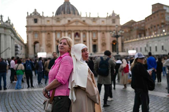 Faithful pose as they wait for the smoke to rise from the chimney on the Sistine Chapel as conclave to elect a new Pope starts, at St Peter's Square in The Vatican, on May 7, 2025. (Photo by Dimitar DILKOFF / AFP)