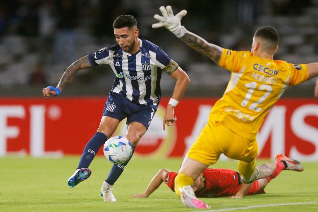 Talleres' forward #07 Nahuel Bustos and Libertad's goalkeeper #12 Rodrigo Morinigo Barbifight for the ball during the Copa Libertadores group stage first round football match between Argentina's Talleres de Cordoba and Paraguay's Libertad at the Mario Alberto Kempes stadium in Cordoba, Argentina, on May 8, 2025. (Photo by Diego Lima / AFP)