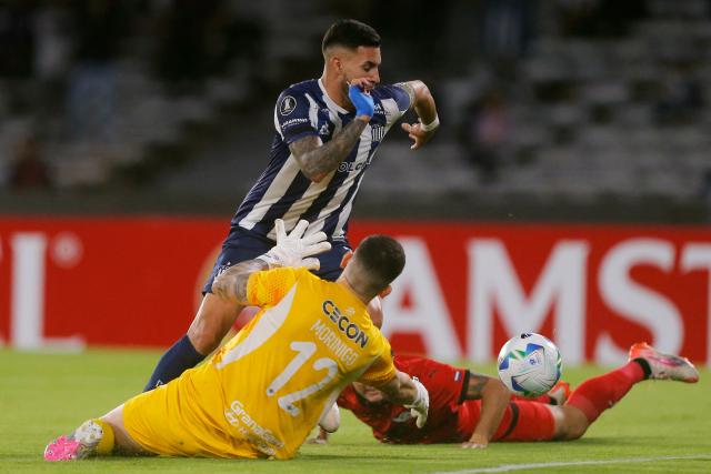 Talleres' forward #07 Nahuel Bustos and Libertad's goalkeeper #12 Rodrigo Morinigo Barbifight for the ball during the Copa Libertadores group stage first round football match between Argentina's Talleres de Cordoba and Paraguay's Libertad at the Mario Alberto Kempes stadium in Cordoba, Argentina, on May 8, 2025. (Photo by Diego Lima / AFP)