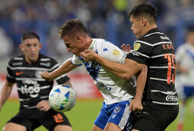 Velez Sarsfield's forward #09 Braian Romero (L) and Olimpia's defender #15 Axel Alfonzo fight for the ball during the Copa Libertadores group stage first round football match between Argentina's Velez Sarsfield and Paraguay's Olimpia at the Jose Amalfitani stadium in Buenos Aires on May 8, 2025. (Photo by JUAN MABROMATA / AFP)